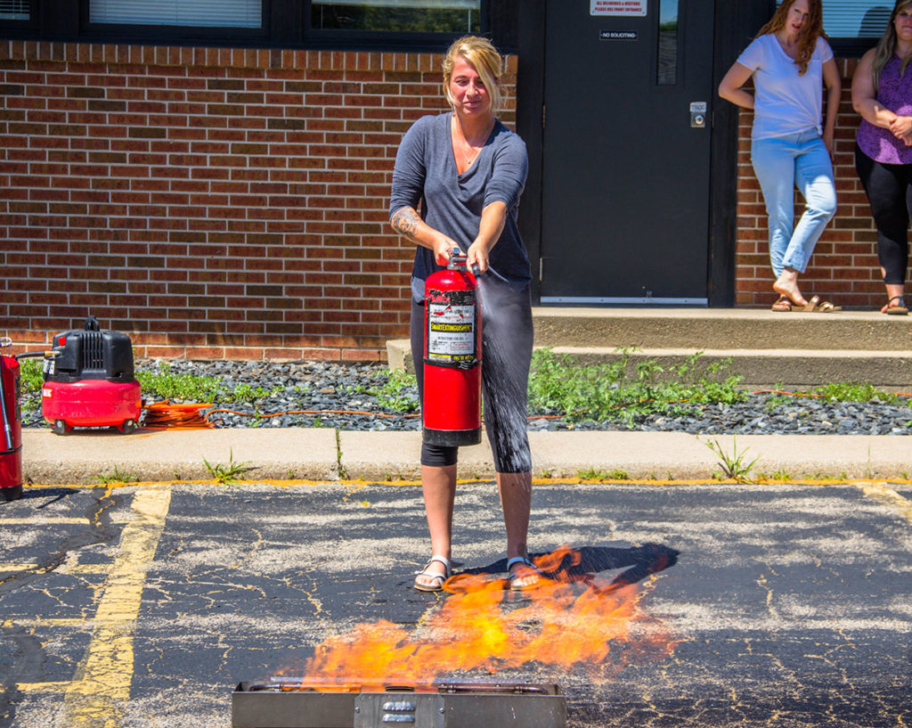 Woman Using Fire Extinguisher