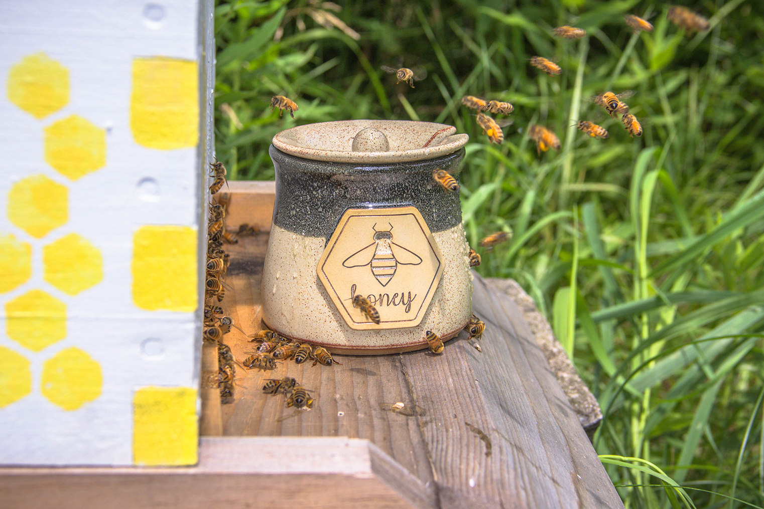 Honey pot next to a beehive