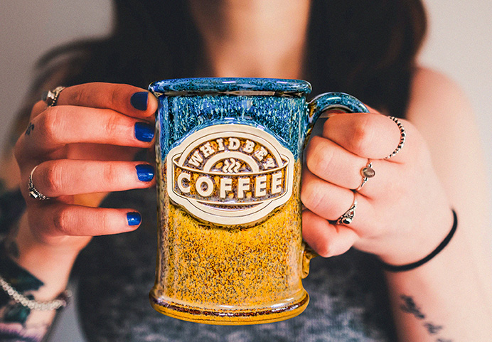 Woman holding stoneware ceramic mug