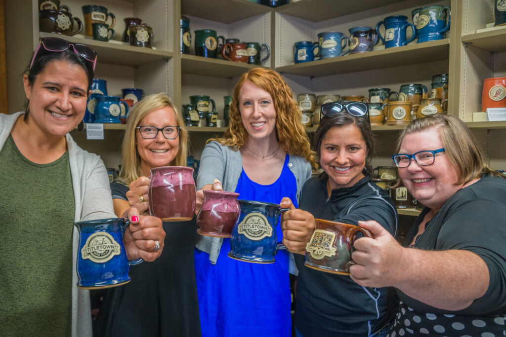 People Raising Stoneware Mugs